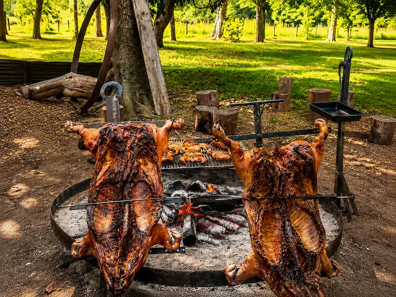 Chanchos asados en espadas al asador preparado al aire libre en El Carmen